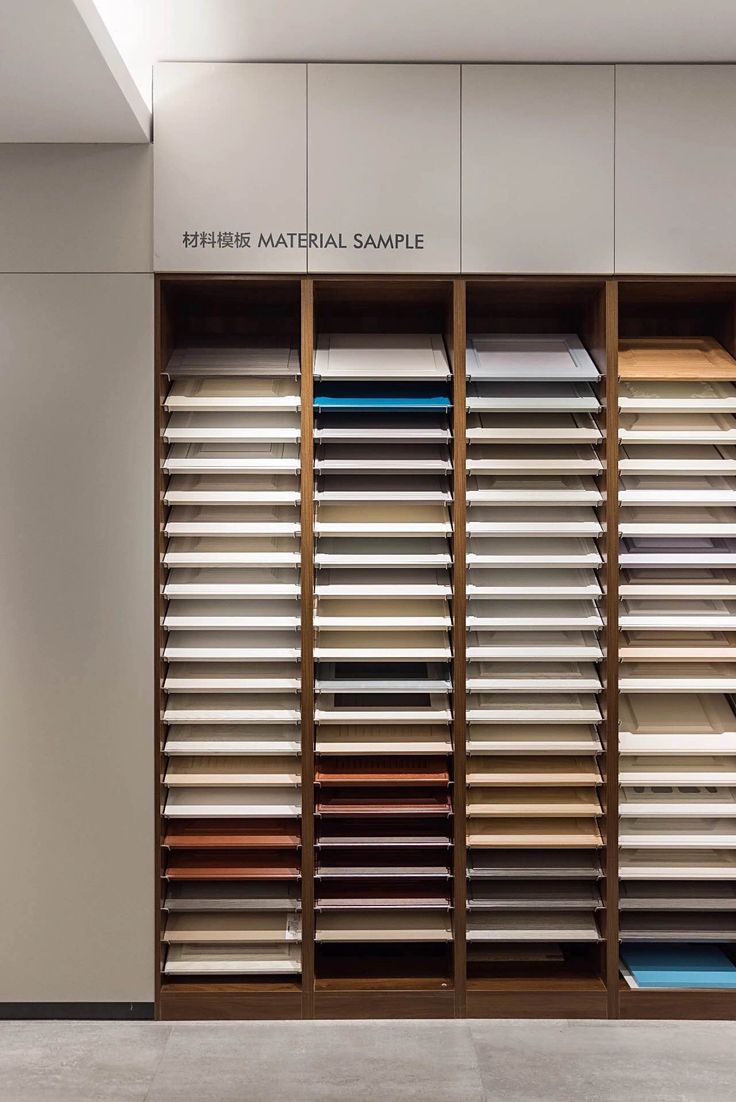 the interior of a clothing store with lots of different colors and materials on display in wooden shelves