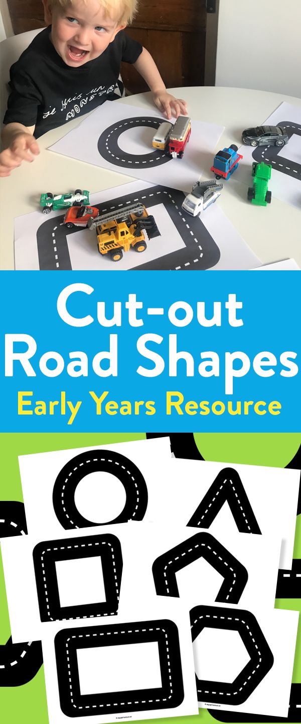 a young boy playing with road shapes on a table