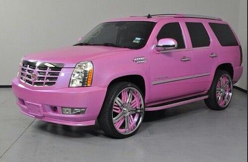 a pink suv with chrome rims parked in a garage next to a white wall