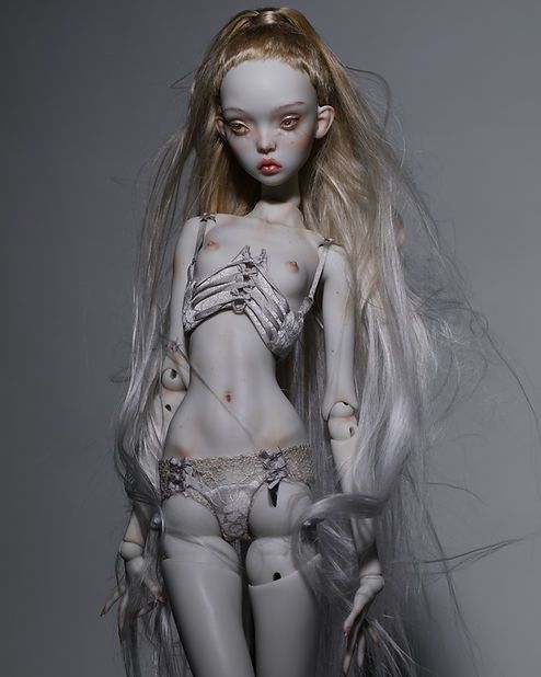 a creepy doll with long hair and white skin