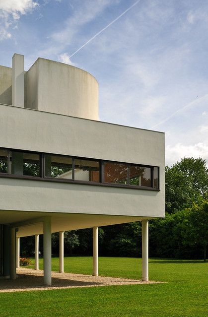 a large white building sitting on top of a lush green field