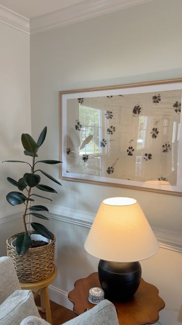 a living room scene with focus on the floor lamp and plant in front of the window