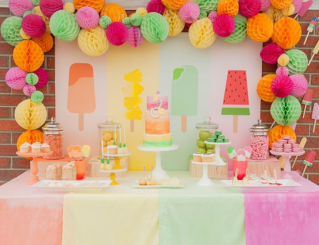 there is a table that has many different decorations on it, including tissue balls and paper flowers