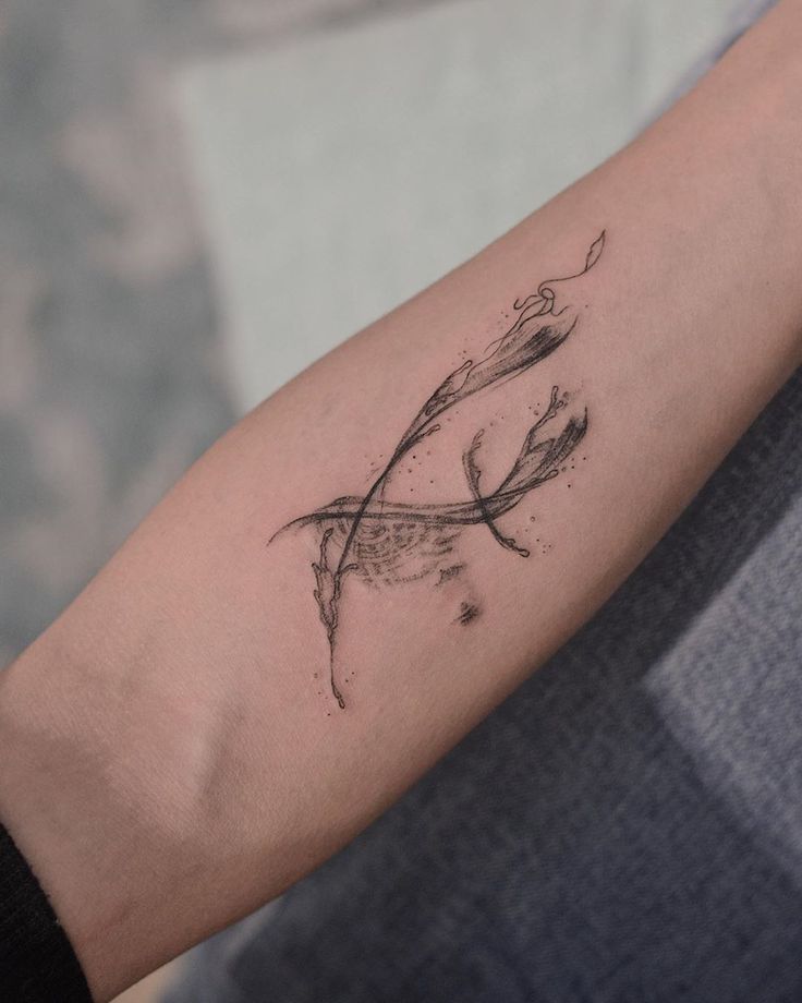 a woman's arm with a tattoo on it that has an arrow and leaves