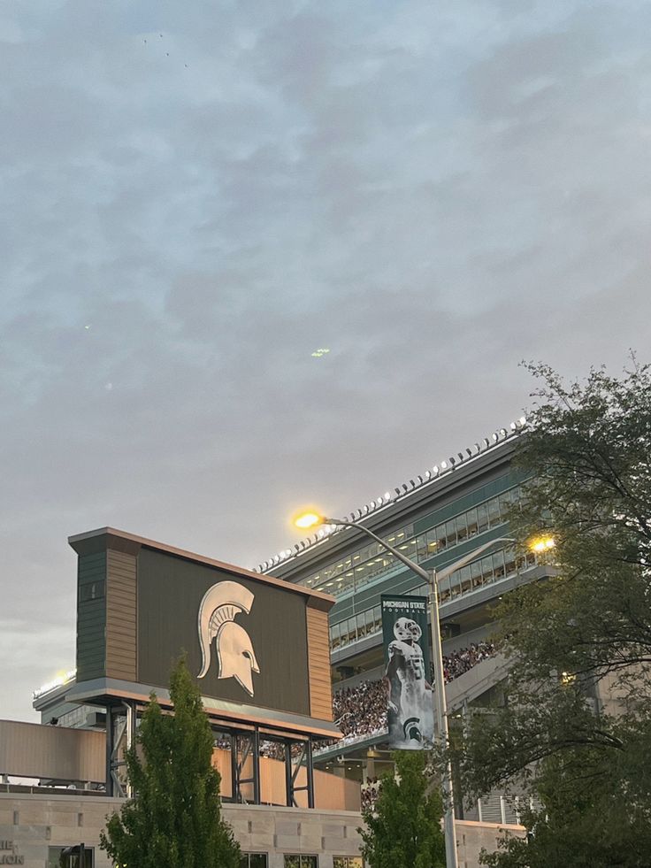 a large building with a spartan logo on it's side and trees in the foreground