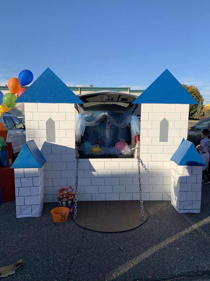 the trunk of a car is open with balloons in the back and on the ground