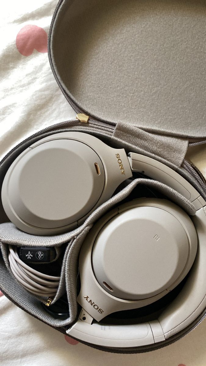 a pair of headphones in a case on a bed