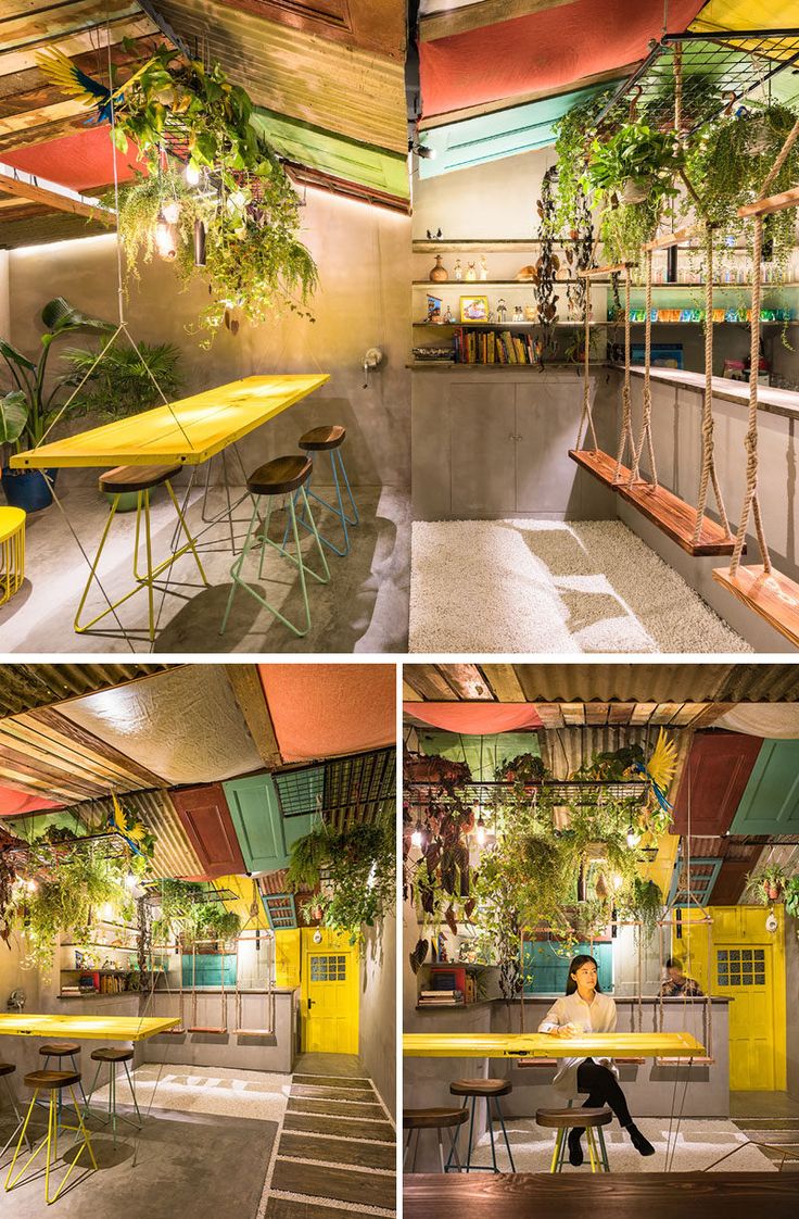 the interior of an indoor cafe with tables and chairs, plants hanging from the ceiling