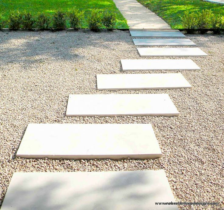 a stone path in the middle of a graveled area