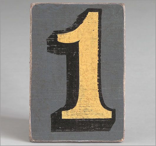 a black and yellow wooden block with the number one painted on it's side