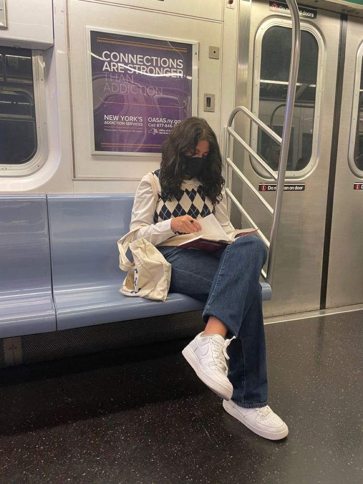 a person sitting on a train reading a book