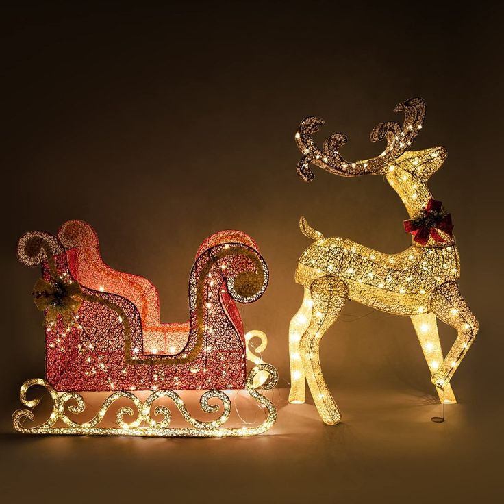 two lighted reindeer sleighs with lights on them, one is red and the other is gold