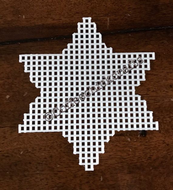 a cross stitched ornament on a wooden surface