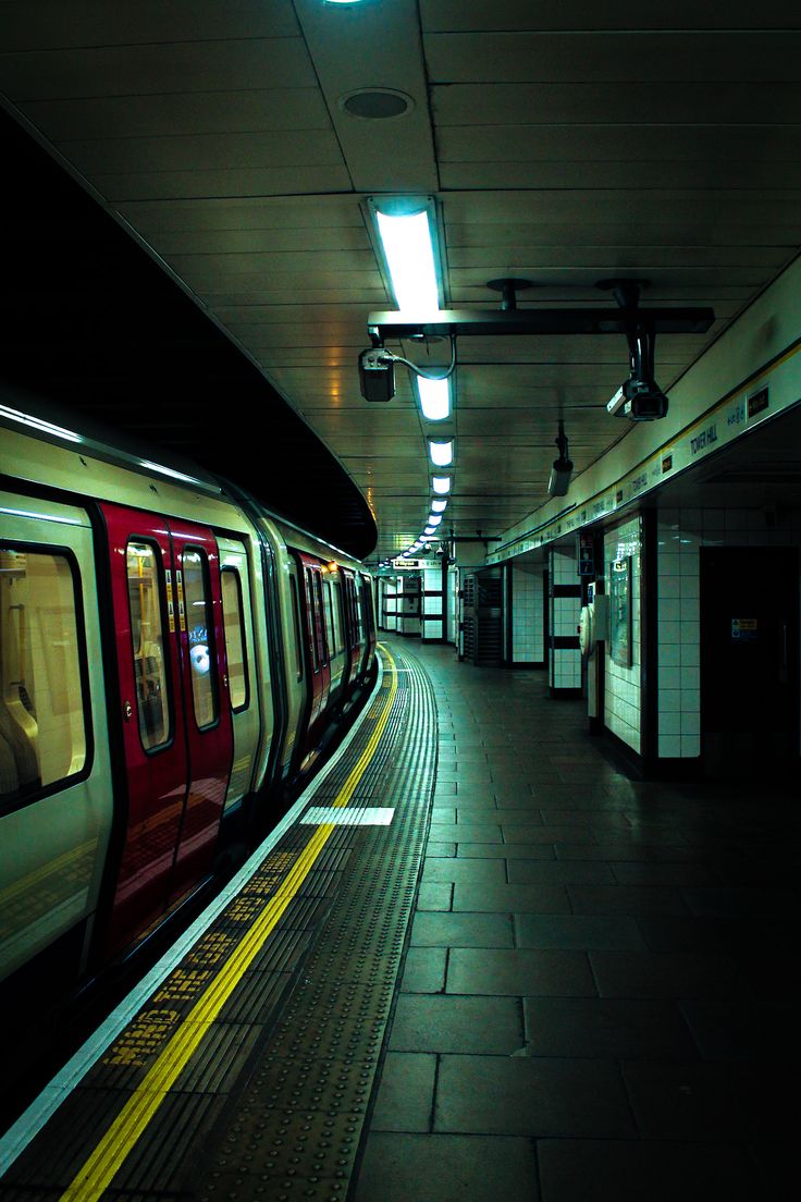 a subway train pulling into a station with its doors open and lights on at night