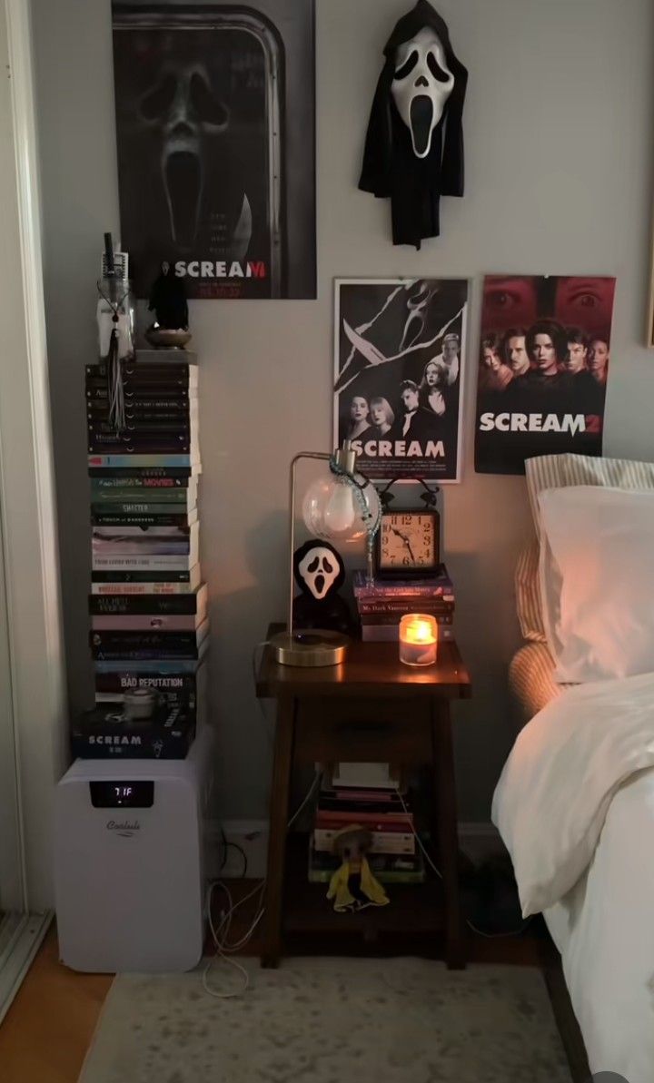 a bed room with a neatly made bed next to a night stand and posters on the wall