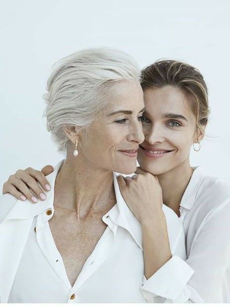 an older woman and younger woman smiling at the camera with their arms around each other