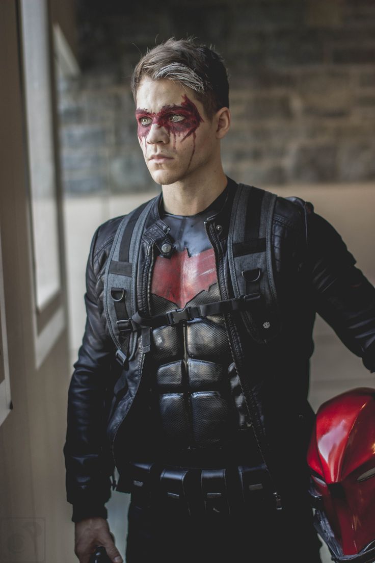 a man dressed up as the dark knight with blood painted on his face and chest