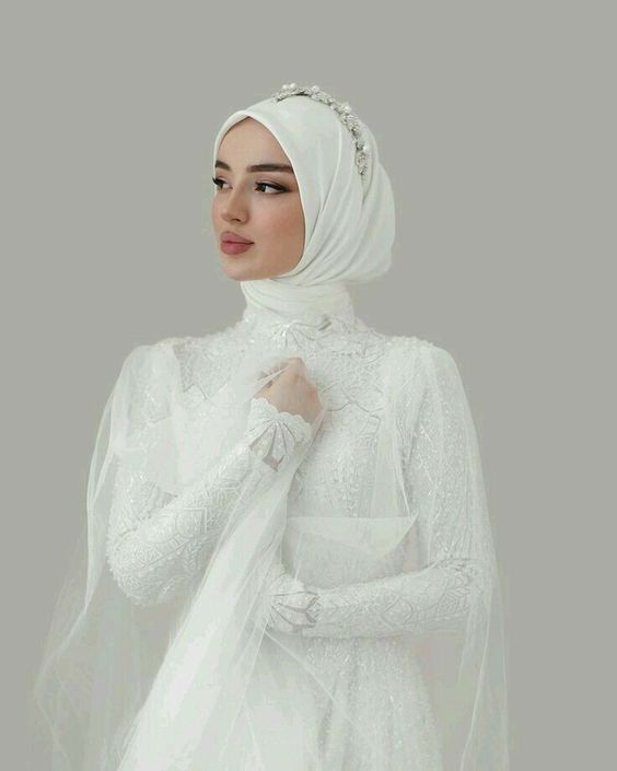 a woman wearing a white veil and dress