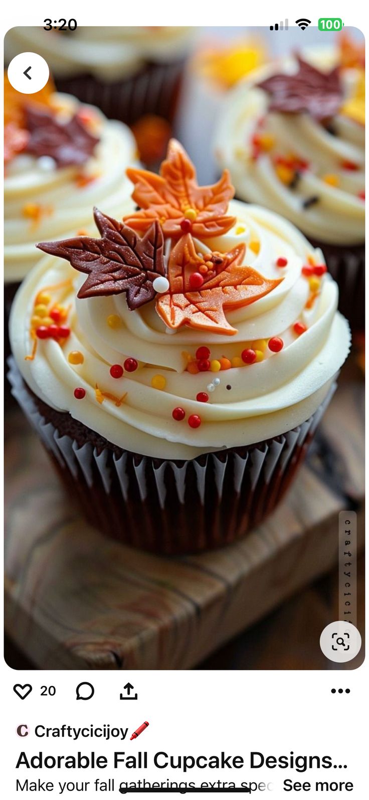 cupcakes with white frosting and fall leaves on them are sitting on a wooden tray