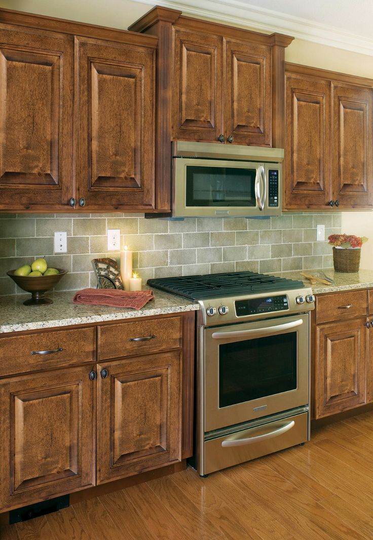 a kitchen with wooden cabinets and stainless steel appliances