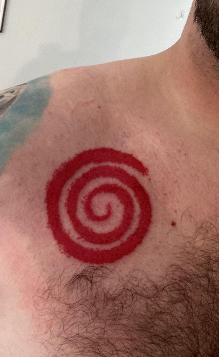 a man's chest with a red and white spiral tattoo on it