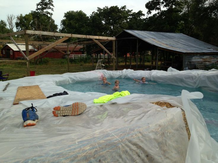 people are swimming in an outdoor pool covered with plastic