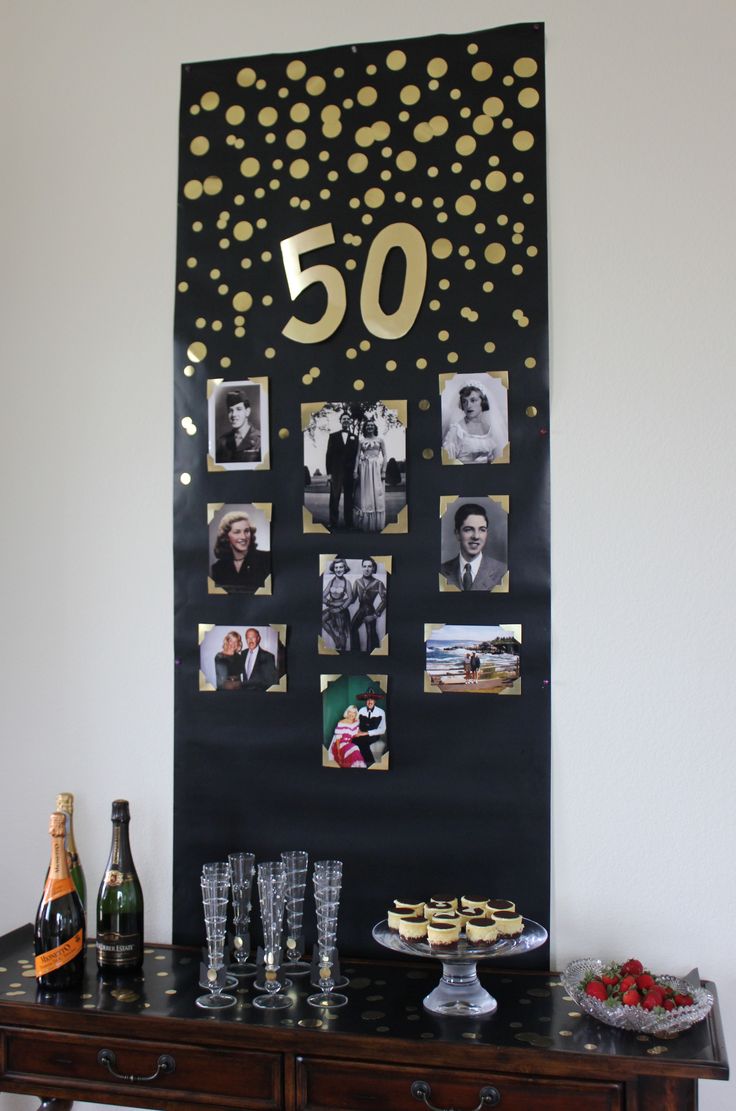 a black and gold 50th birthday party with pictures on the wall, wine glasses, cake and champagne