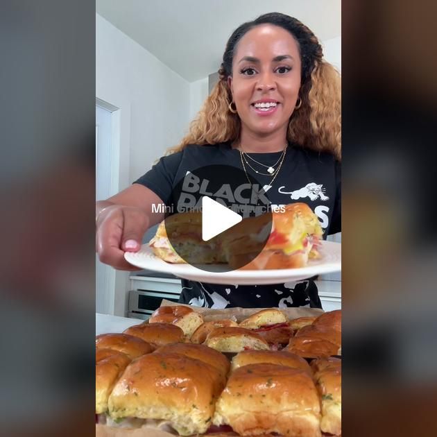 a woman holding a plate with sandwiches on it