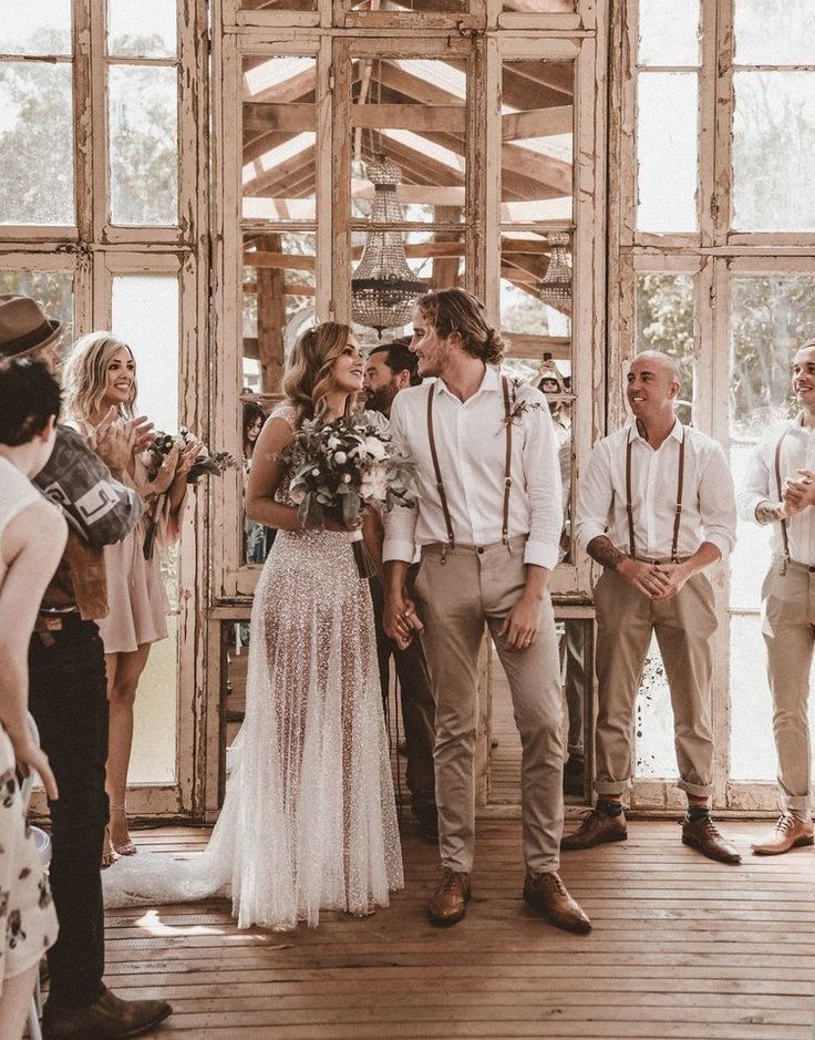 a group of people standing next to each other in front of a wooden structure with lots of windows