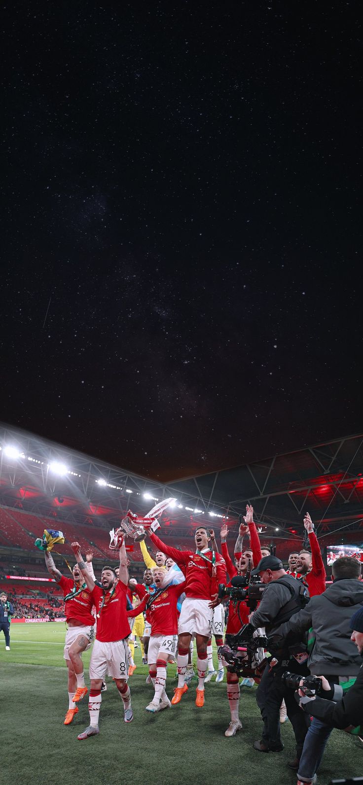 the soccer team is celebrating their victory over the crowd at the stadium with their hands in the air