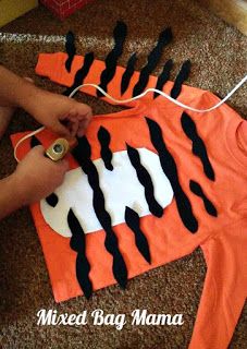 someone is making a tiger shirt out of an orange t - shirt with black and white stripes