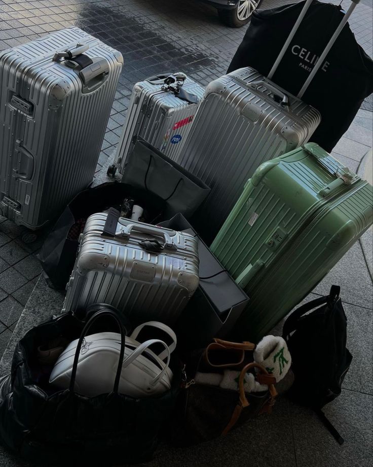 several pieces of luggage sitting on the ground next to each other in front of a car