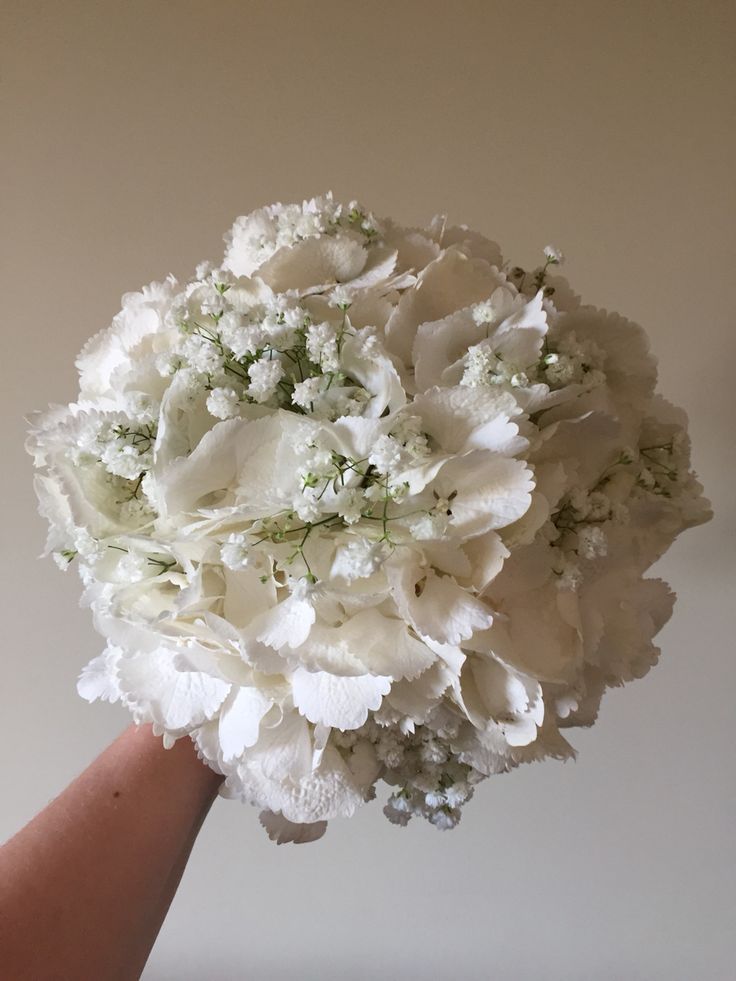 a bouquet of white flowers in someone's hand