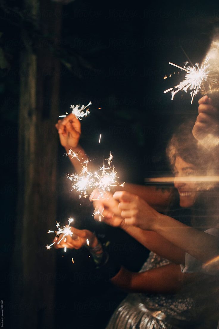 two girls are holding sparklers in their hands