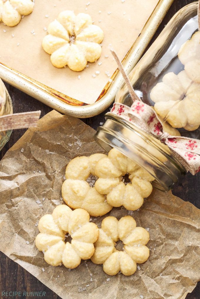 some cookies are sitting on wax paper next to a cookie tin