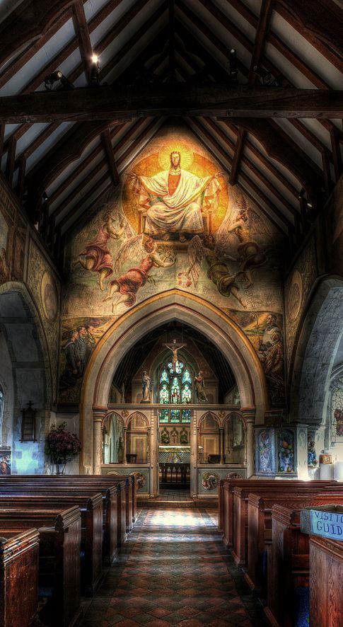 the interior of an old church with stained glass windows and pews on both sides