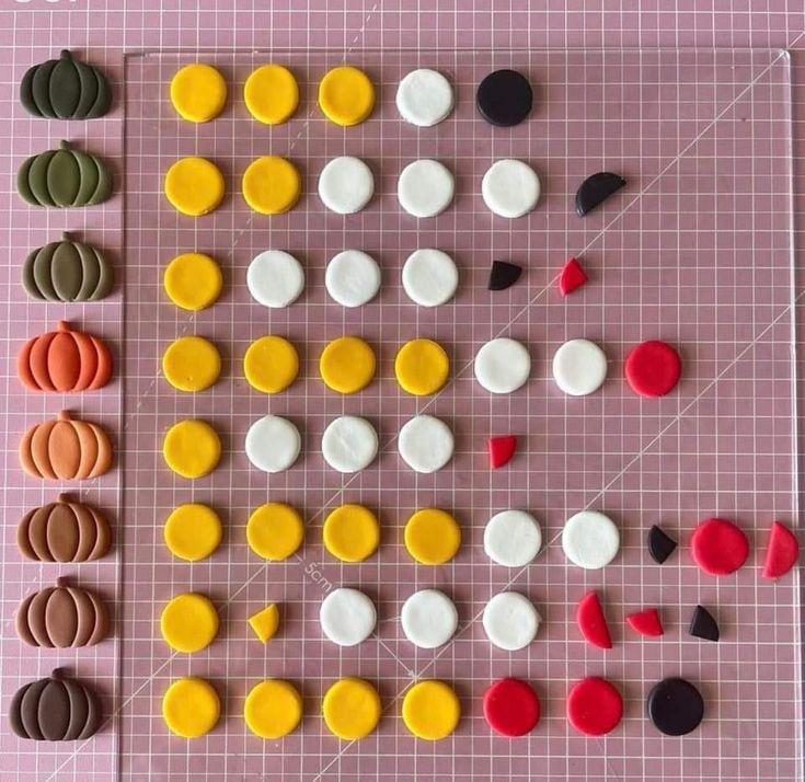 several different types of buttons on a piece of pink paper with white and yellow circles