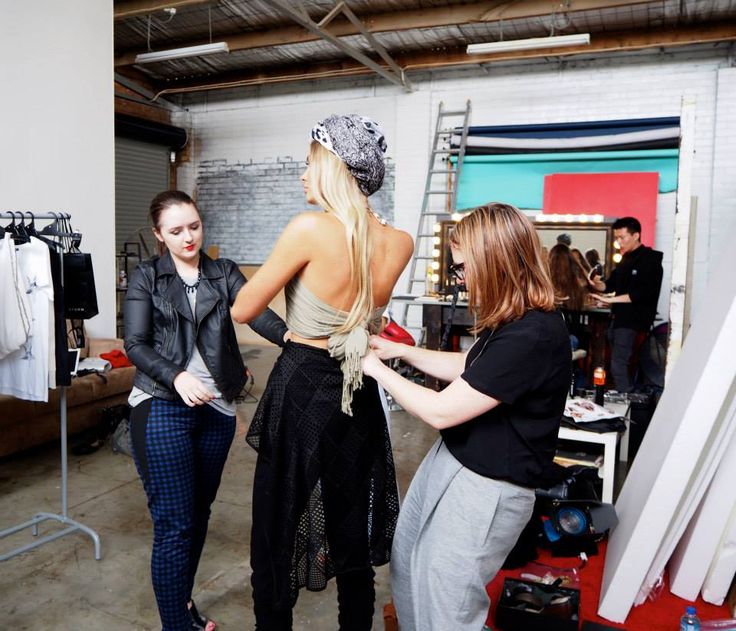 three women standing in front of a rack of clothes