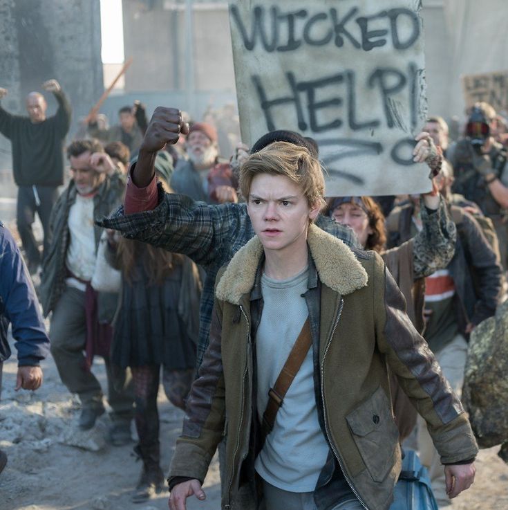 a group of people walking down a street holding signs