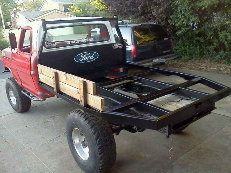 a red truck is parked on the side of the road with its flatbed open