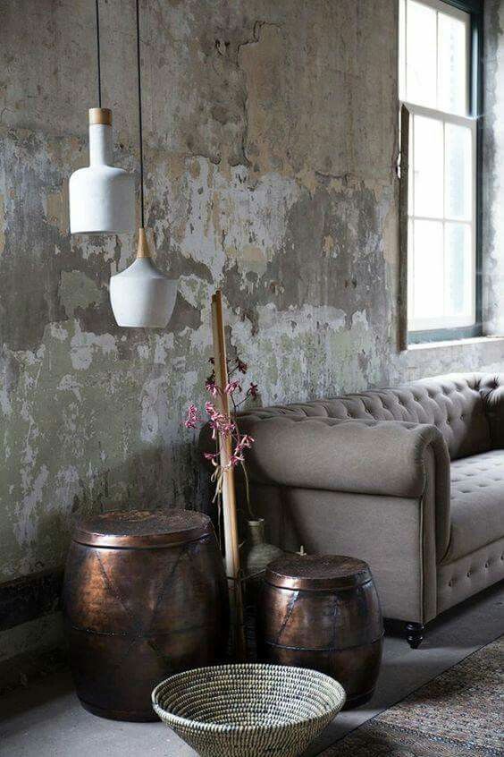 a living room filled with furniture next to a wall covered in peeling paint on the walls