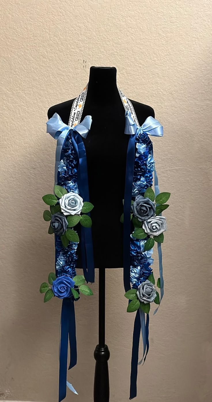 a black mannequin with blue ribbon and flowers on it