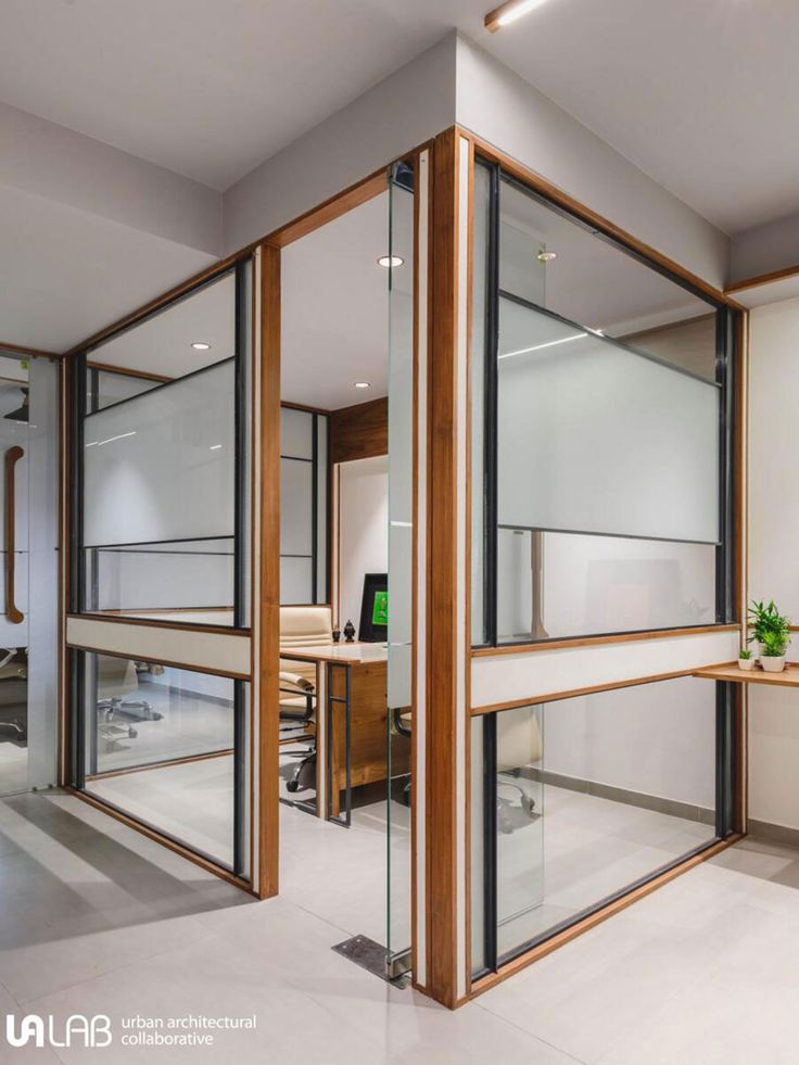 an office with glass walls and wooden accents