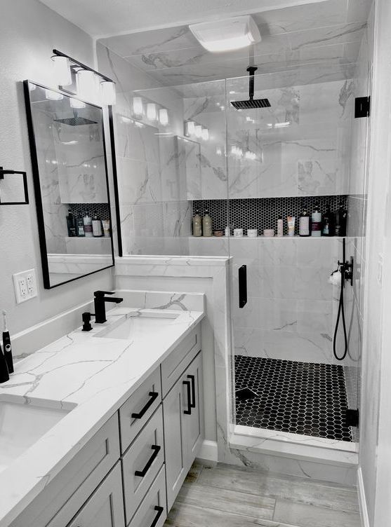 a bathroom with two sinks and a shower stall in the corner, all white marble