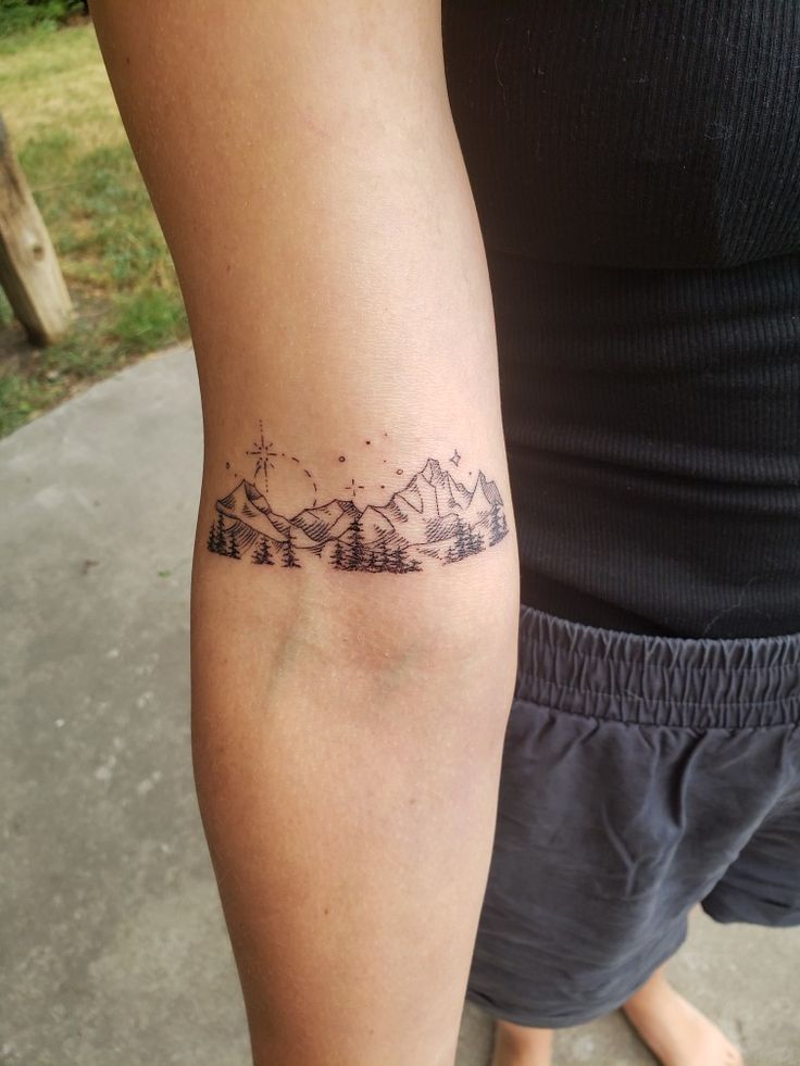 a person with a mountain tattoo on their arm