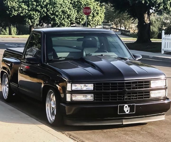 a black truck is parked on the side of the road