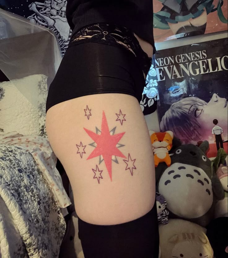 a woman's thigh with stars on it and a book in the back ground