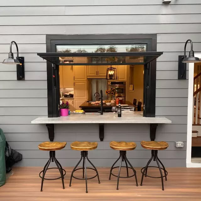 three stools sit at the bar in front of an open kitchen door and window