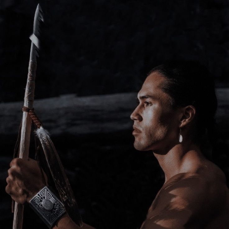 a man holding a bow and arrow in his hand while looking off into the distance