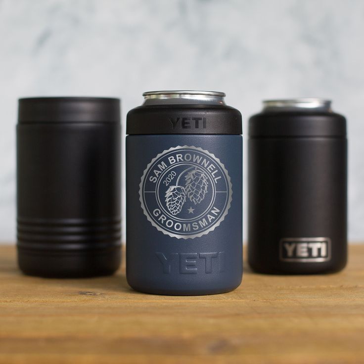 three black canisters sitting on top of a wooden table